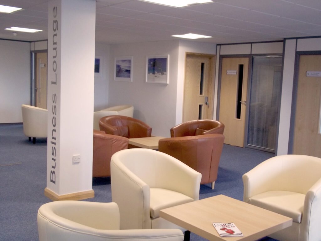 The Bsiness Lounge. Comfy arm chairs around small tables.