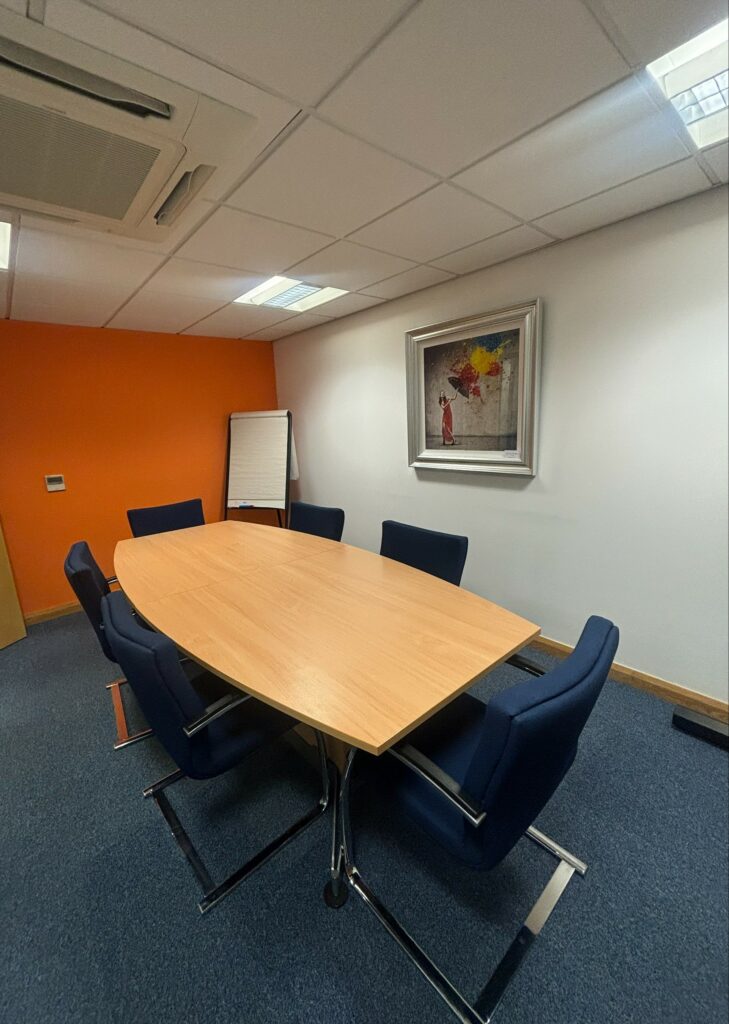 Table to fit 6 people around, with flipchart paper at the other end of the room.