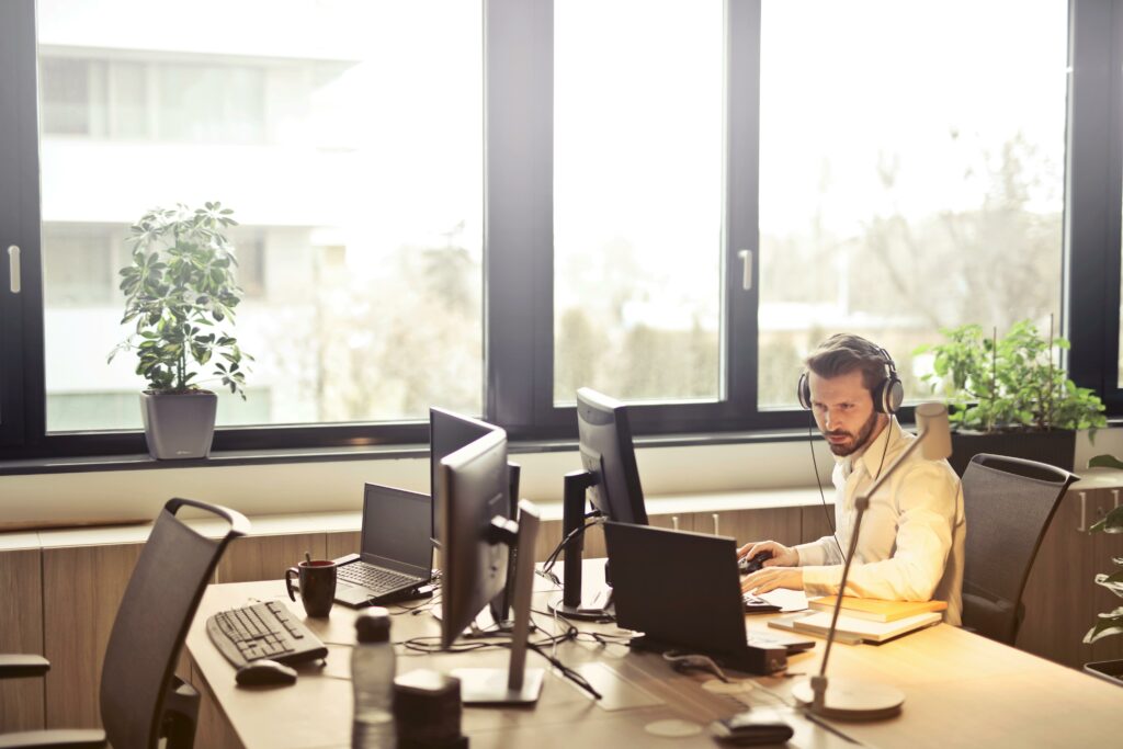 Man sat at a desk with a telephone headset on.